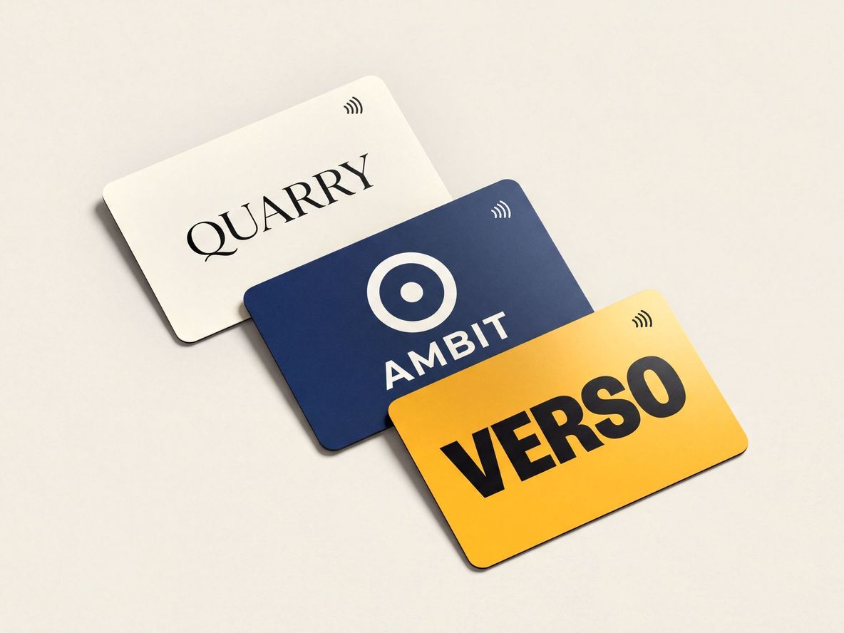 Three cards from three different companies fanned out on a pale studio surface — cobalt, coral and emerald matte PVC, each with its own logo centred and the contactless indicator in the corner